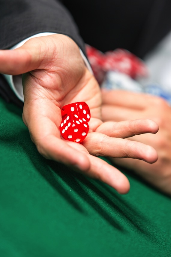 Un jugador lanza los dados en una mesa de póker. Reta al casino. Foto: Shutterstock