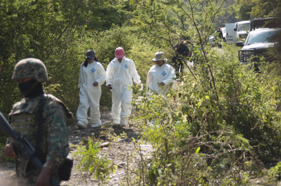 Vestidos con trajes blancos, los expertos analizan el perímetro con técnica de barrido y trazan líneas con banderas para identificar posibles indicios. Foto: Cuartoscuro.