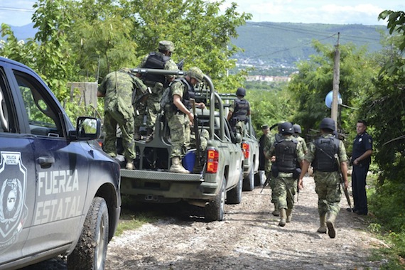 Elementos de las fuerzas de seguridad mantienen acordonada la zona donde se localizaron las fosas. Foto: Cuartoscuro 