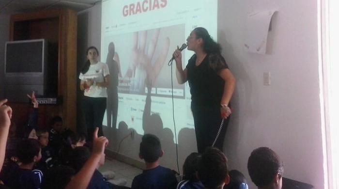 Lucy durante una plática en una escuela, los niños recolectaron croquetas para los perritos de la AC. Foto: Cortesía.