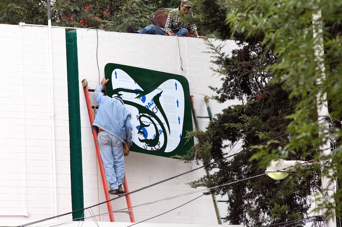 Trabajador coloca el logo del IMSS en el edificio que se construyó a marchas forzadas. Foto: Francisco Cañedo, SinEmbargo 