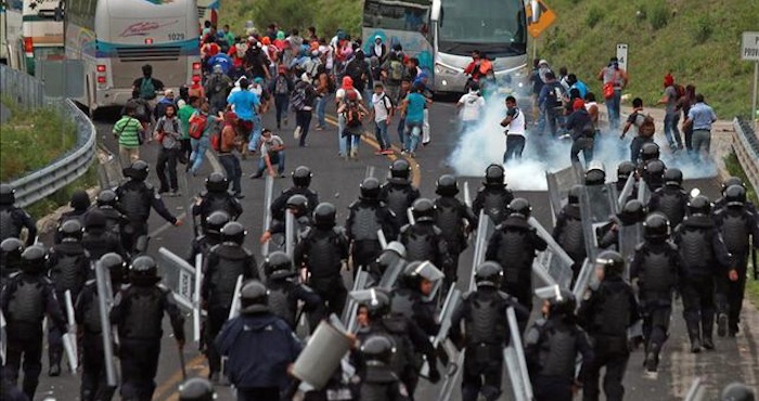 Familiares de los 43 estudiantes desaparecidos en Iguala y alumnos de la Normal Rural de Ayotzinapa que se dirigían a Chilpancingo, capital del sureño estado de Guerrero, se enfrentan con la policía que bloqueaba el paso de los manifestantes el pasado 6 de junio. Foto: EFE