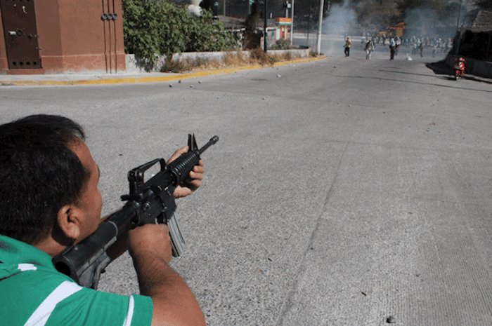 En el desalojo de la Autopista del Sol ocurrido el 12 de diciembre de 2011, normalistas fueron atacados con armas ilegales. Foto: Cuartoscuro.