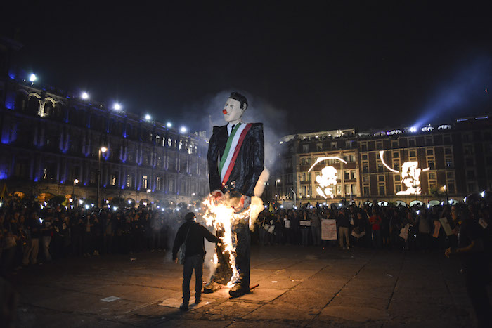 Manifestantes incendiaron una efigie de Enrique Peña Nieto en la explanada del Zócalo capitalino luego de una movilización para exigir justicia por Ayotzinapa. Foto: Cuartoscuro 