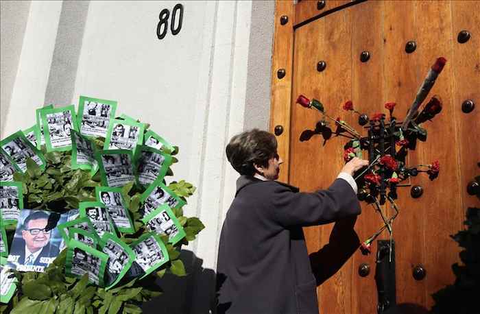 La senadora chilena e hija del presidente Salvador Allende, Isabel Allende, deja flores en Morande 80, la puerta lateral del Palacio de La Moneda. Foto: Efe