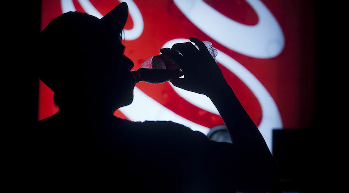 Hombre tomando Coca-Cola.