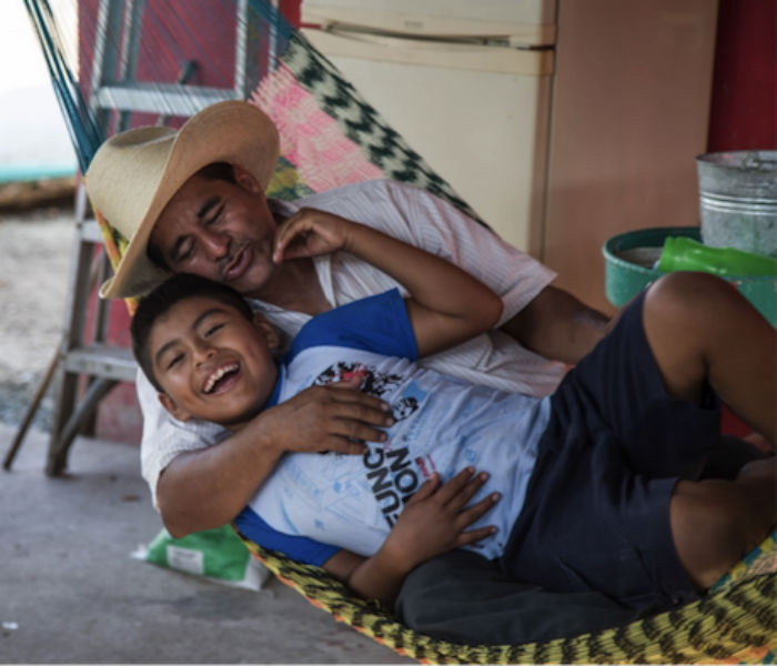 Rubicel López comparte un momento de frivolidad con su niño, en su casa, cerca del lugar de la explosión. Foto del autor.