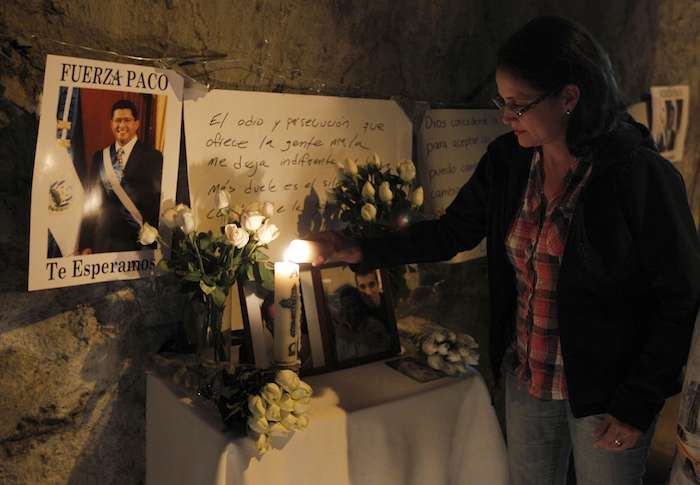 Una salvadoreña enciende una vela a las afueras del hospital donde falleció el ex presidente salvadoreño Francisco Flores. Foto: EFE.