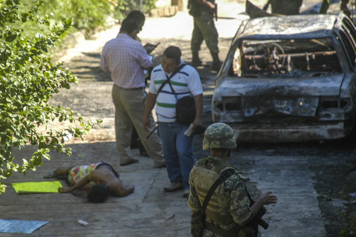 10 de noviembre de 2015. Un hombre asesinado en Acapulco, Guerrero, junto a un auto incendiado. Foto: Cuartoscuro