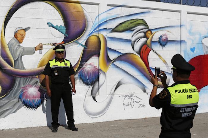 En Esta Imagen Del Viernes De Febrero De Un Agente De Policía Toma Una Foto a Un Compañero Ante Un Mural Con La Imagen Del Papa Francisco Como Artista Del Graffiti En Ecatepec El Suburbio Más Populoso De Ciudad De México Foto Apdario Lopez mills