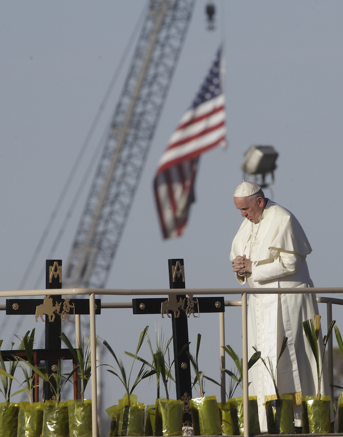 DÍA 5: Fotografía para la historia: el Papa reza con un pie en México y mirando a Estados Unidos por los migrantes. Foto: AP