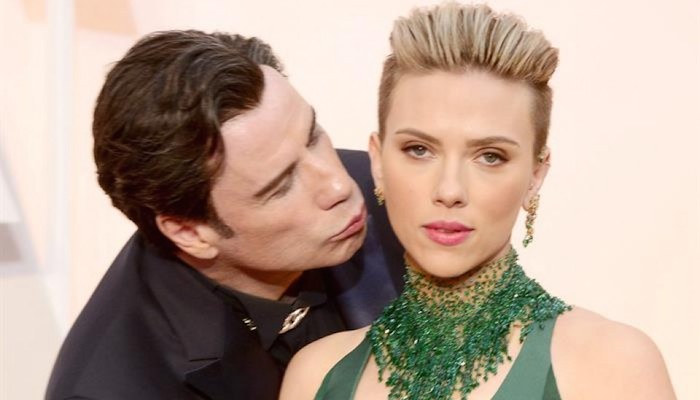 John Travolta sorprende con un beso a Scarlett Johanson durante la alfombra roja de los Oscar 2015. Foto: Archivo/EFE