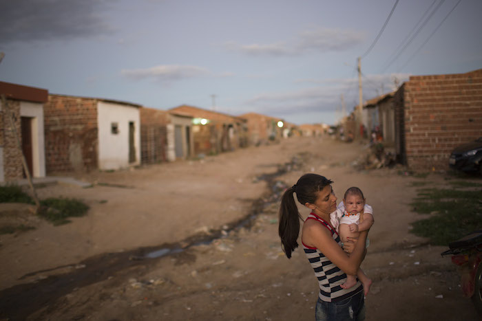 Angelica Pereira carga a su hija Luiza, quien nació con microcefalia, afuera de su casa en Brasil. Foto: AP 