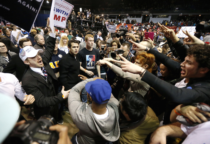 Partidarios del precandidato presidencial republicano Donald Trump, izquierda, se enfrentan con manifestantes después de la cancelación de un mitin en la Universidad de Illinois. Foto: AP