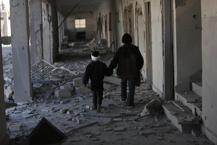 Dos niños, entre los escombros de lo que anteriormente fue una escuela en Guta. Foto: Save the Children.