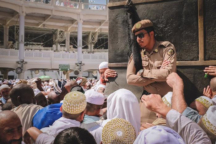 Un guardia vigila que los peregrinos no se peleen al intentar tocar "la piedra negra". Foto: Vice/Yasin Osman