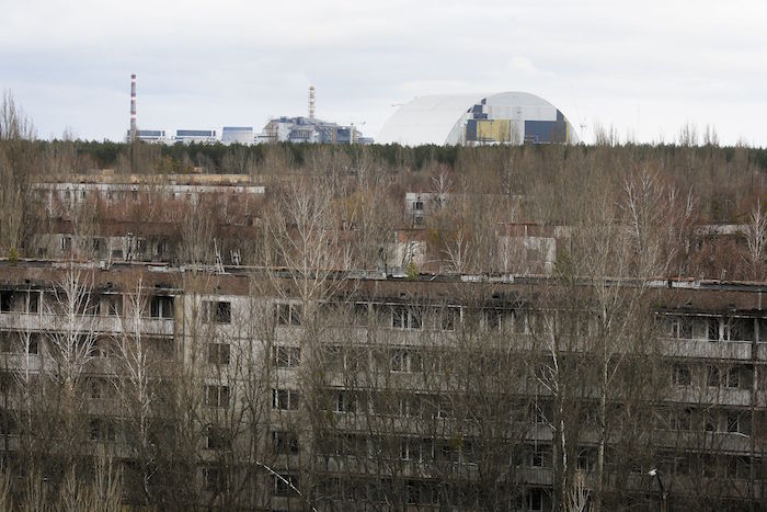 Edificios abandonados de Pripyat, la ciudad que alojaba a los trabajadores de la planta nuclear de Chernobyl. En el fondo se ve la estructura en forma de arco que está siendo construida para cubrir la planta y evitar fugas de gases tóxicos relacionado con la explosión registrada hace 30 años en la planta. Foto: AP.