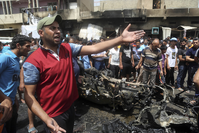 Ciudadanos observan la escena tras la explosión de un coche bomba junto a un mercado abarrotado en el distrito de Sadr City, en la capital iraquí. Foto: AP