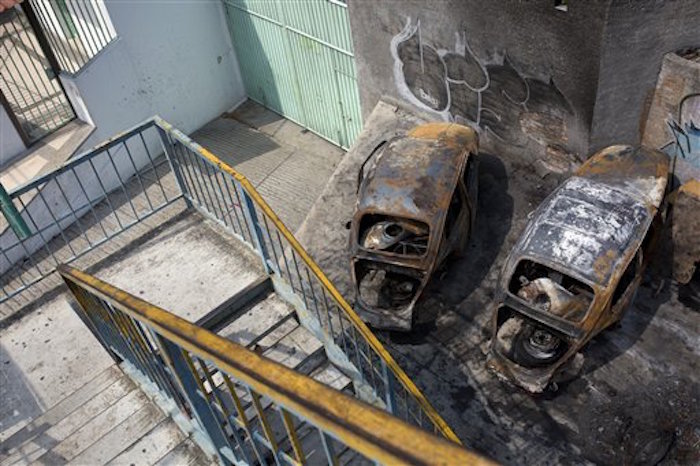 Vehículos incendiados por durante un tiroteo ocurrido hace dos años en el centro turístico, según relataron vecinos. Foto: AP 