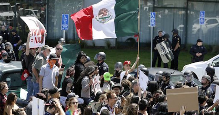 Un manifestante ondea una bandera de México durante una protesta. Foto Eric Risberg/AP