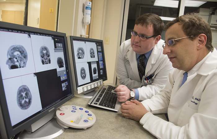 En esta foto proporcionada por la Universidad de Washington se observan el profesor asociado de neurología de la Escuela de Medicina de la universidad, Beau Ances, derecha, y Matthew Brier, estudiante de la universidad, mientras examinan una tomografía PET de un paciente con alzhéimer en St. Louis. Foto: AP