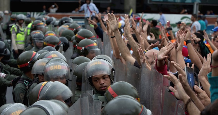 Manifestantes Antigobierno Alzan Los Brazos Frente a Una Hilera De Guardias Nacionales Que Le Impiden Llegar a La Sede Del Consejo Nacional Electoral En Caracas Venezuela Foto Ap