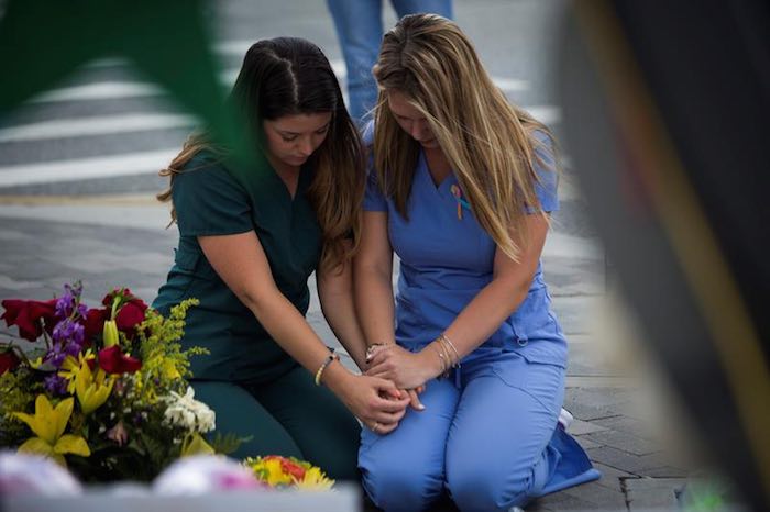 Unas mujeres oran junto a las cruces de un memorial en tributo a las víctimas del tiroteo de Orlando, hoy jueves 16 de junio de 2016, cerca la Centro Médico Orlando Regional, de Orlando, Florida. Foto: EFE