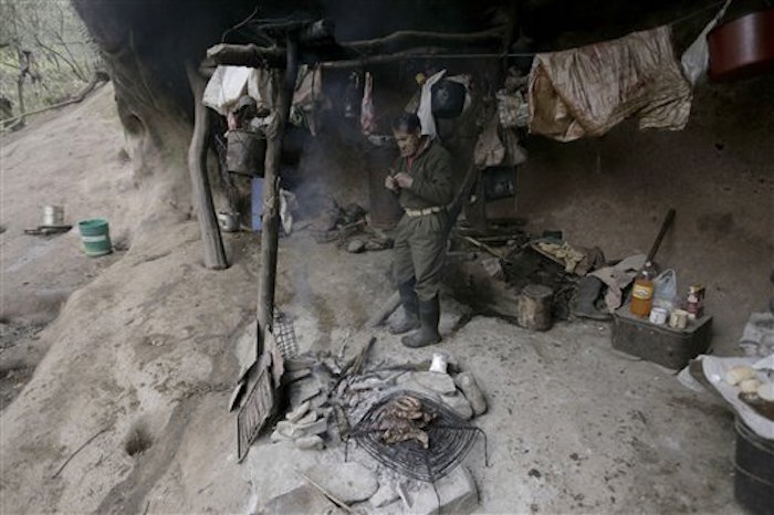 Pedro Luca se prepara alimentos dentro de una cueva en San Pedro de Colalao, Argentina, Foto: AP 