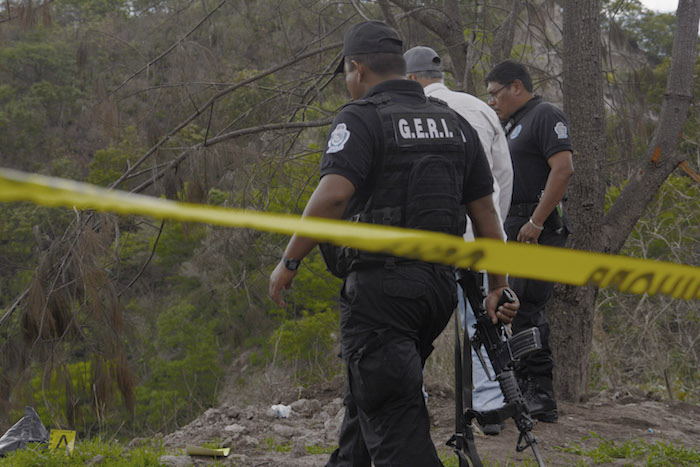 CHILPANCINGO, GUERRERO, 04JULIO2016.- En el tramo del viejo libramiento Chilpancingo-Tixtla, en el punto conocido como el Cerro Machohua, cerca del basurero en una barranca, fue localizado el cuerpo de un hombre cubierto con una bolsa negra, trascendió que se trataba del hombre que fue atacado a balazos en la Tixtla y que presuntamente en vida se llamó Gelacio Navarrete Morales y que impartió el taller de talabartería en la normal rural de Ayotzinapa ubicada en Tixtla. Al lugar del hallazgo se congregaron policías de los dos órdenes de Gobierno y el cuerpo fue trasladado por el servicio médico forense para la necropsia de ley. FOTO: JOSÉ I. HERNÁNDEZ / CUARTOSCURO.COM