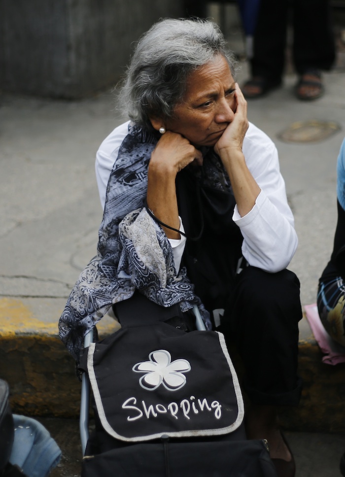 La imagen tomada el 8 de julio de 2016, de una mujer que espera en una fila en el exterior de un supermercado en Caracas. Foto: Ariana Cubillos, AP