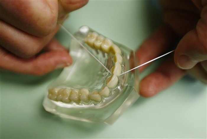 El doctor Wayne Aldredge, presidente de la Academia Estadounidense de PeriodontologÌa, de especialistas en encÌas e implantes dentales, muestra cÛmo se debe usar el hilo dental. Foto: AP