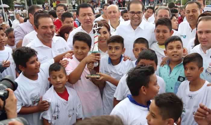 En la imagen, Miranda Nava (izq.), Miguel Ángel Osorio Chong (centro) y José Ignacio Peralta (der.) posan junto a un grupo de menores en la Unidad Deportiva de Colima. Foto: Twitter [@LuisEMirandaN].