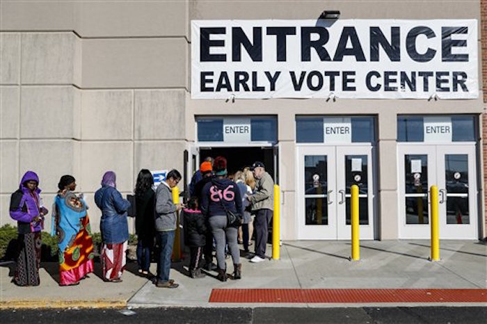 Varios votantes hacen fila frente a la Junta de Elecciones del Condado Franklin, el lunes 7 de noviembre de 2016, en Columbus, Ohio. El letrero dice: "Entrada. Centro de votaciÛn anticipada". La Corte Suprema de Estados Unidos y jueces federales en dos estados rechazaron una solicitud de los demÛcratas el lunes para que impidieran lo que lÌderes partidistas dicen son los planes de los partidarios del candidato republicano Donald Trump para hostigar e intimidar a los votantes el dÌa de las elecciones. (AP Foto/John Minchillo)