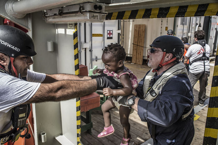 Nael Nasser de Azul Mediador Cultural a Bordo Del Bourbon Argos Ayuda a Una Niña Tras Quitarle Su Pequeño Salvavidas en Su Desesperación Los Padres Y Madres Arrojan a Sus Hijos a Nuestros Brazos Y Confían Ciegamente En Unos Extraños Como Nosotros Para Que Los Llevemos Al Barco De Rescate Resulta Desgarrador Ver Cómo Familias Con Niños De Tan Solo Unos Meses De Edad En Este Tipo De Situaciones Límite Afirma Sebastian Stein Coordinador De Msf En El Argos Fotografía Francesco Zizolanoor