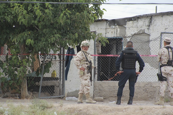 Un militar y un policía afuera de una casa en Ciudad Juárez. Foto: Cuartoscuro. 