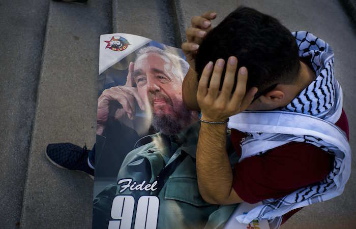 El estudiante palestino de medicina Adham Motawi, con una imagen de Fidel Castro, se sostiene la cabeza incrédulo durante una reunión en honor de Castro en La Habana. Foto: AP. 