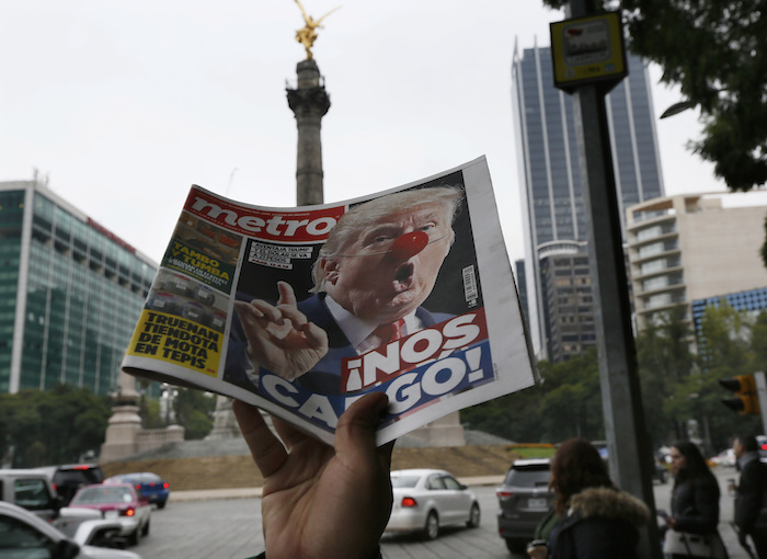 Un vendedor ambulante exhibe un periódico con una imagen de Donald Trump con nariz de payaso y un titular que dice "¡Nos cargó!" frente al monumento del Ángel de la Independencia en la Ciudad de México, el miércoles 9 de noviembre de 2016. Foto: AP/Marco Ugarte)