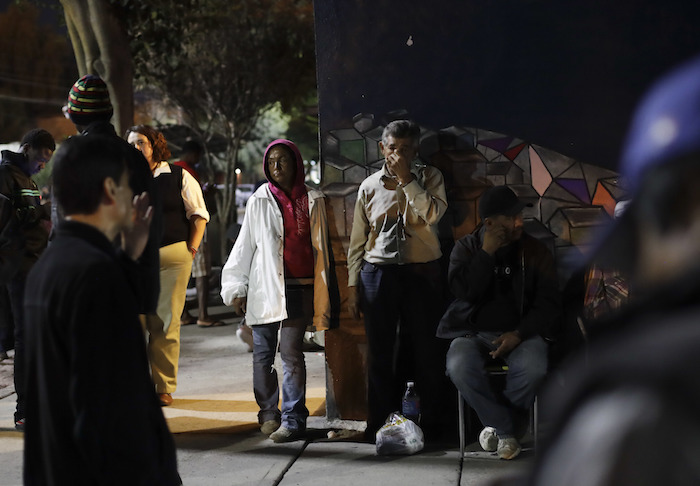 Gente ante un refugio para migrantes que viajan hacia Estados Unidos y migrantes deportados. Foto: AP