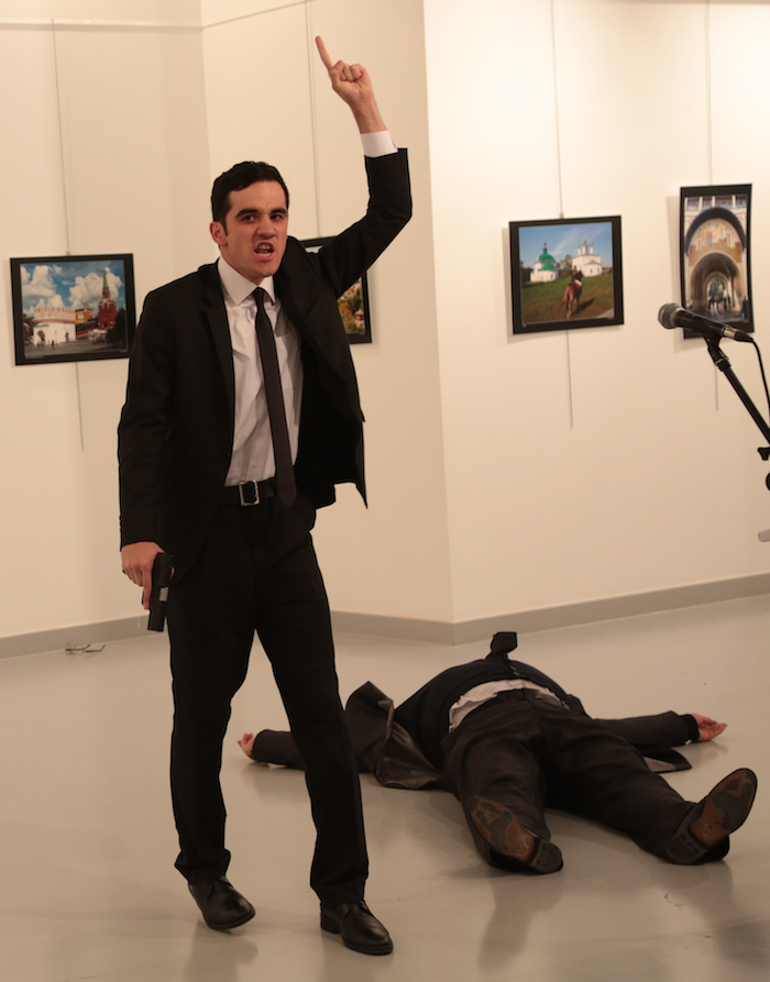 El policía gesticula luego de herir a disparos al embajador ruso ante el gobierno de Turquía Andrei Karlov, en el piso, durante una exposición fotográfica en Ankara. Foto: AP /Burhan Ozbilici