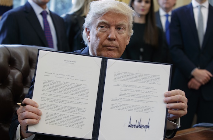 El Presidente Donald Trump muestra la firma de la orden ejecutiva que emitió sobre el oleoducto. Foto: AP. 