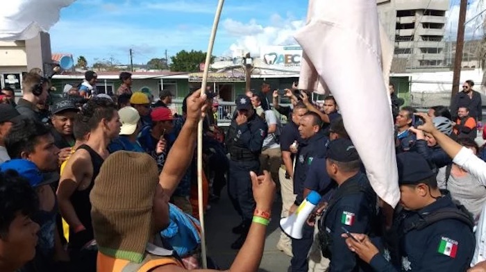 Migrantes de la caravana marchan hacia la garita de El Chaparral en la frontera con EU