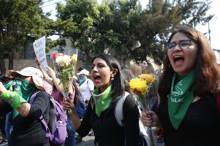 Mujeres lanzan consignas con flores en las manos mientras se dirigen al edificio de apartamentos en que Ingrid Escamilla fue asesinada y desollada, en Ciudad de México, el sábado 15 de febrero de 2020. En el bloque de departamentos del barrio humilde e inseguro donde vivía Escamilla se instaló un pequeño altar con flores, fotos y veladoras donde mujeres de todas las edades compartían dolor y testimonio como parte de una de las varias protestas realizadas el sábado en todo el país contra la violencia de género. Foto: Ginnette Riquelme, AP