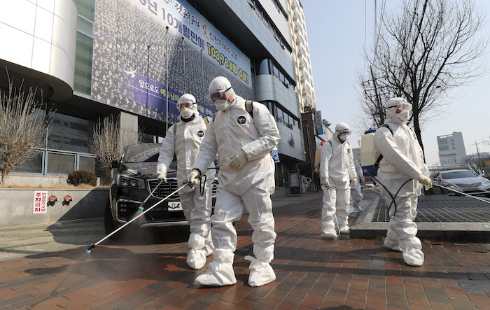 Trabajadores rocían desinfectante frente a una iglesia en la ciudad de Daegu, Corea del Sur, el jueves 20 de febrero de 2020. Foto: Kim Jun-beom/Yonhap vía AP