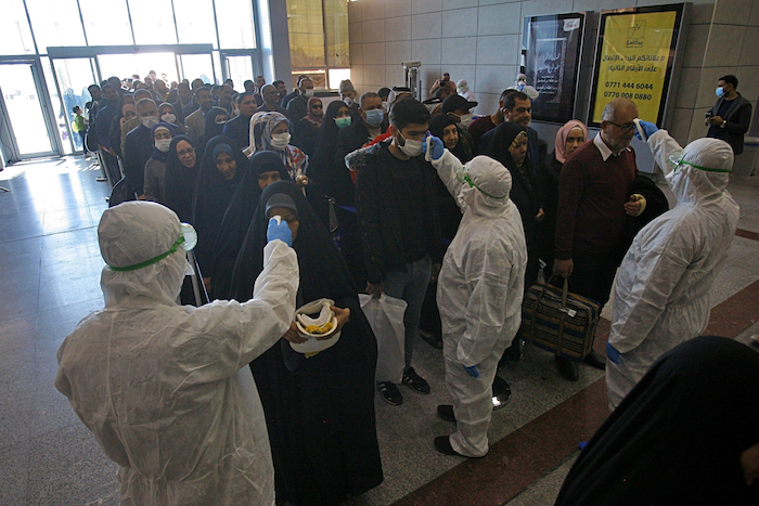 Trabajadores de la salud verifican a los pasajeros que llegan de Irán al aeropuerto de Najaf, en Irak, el viernes 21 de febrero de 2020. Ya se han descubierto viajeros procedentes de Irán infectados con un nuevo coronavirus en Líbano y Canadá. Foto: Anmar Khalil, AP