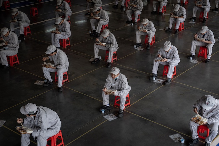 Trabajadores de una fábrica de Wuhan, en la provincia china de Hubei donde se localizó el epicentro de la pandemia de coronavirus, hacen su descanso para el almuerzo guardando el metro y medio de distancia de seguridad establecido para evitar el contagio de la enfermedad. Foto: EFE/EPA/Yi Xin