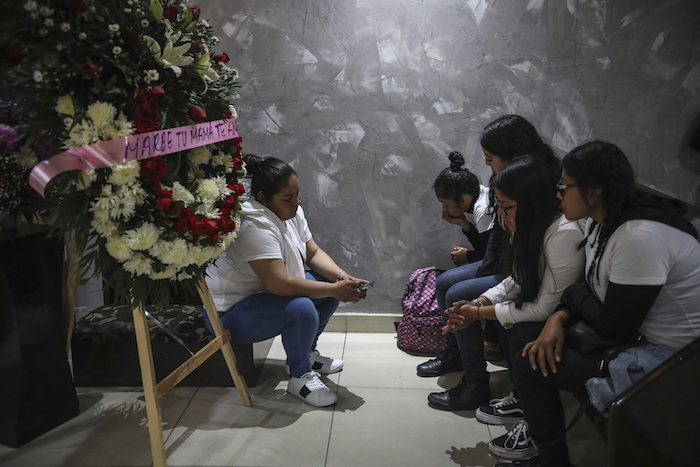 Amigas de la mujer asesinada Marbella Valdez se sientan junto a una corona de flores con el texto "Marbe, tu mamá te ama", junto a su ataúd durante el funeral en una funeraria de Tijuana, México, el jueves 13 de febrero de 2020. Foto: Emilio Espejel, AP