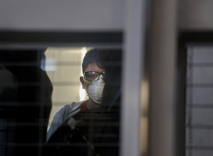 Un pasajero con una mascarilla usa un elevador antes de abordar un vuelo en el Aeropuerto Internacional Arturo Benítez en Santiago, Chile, 3 de marzo de 2020. Foto: Esteban Félix, AP