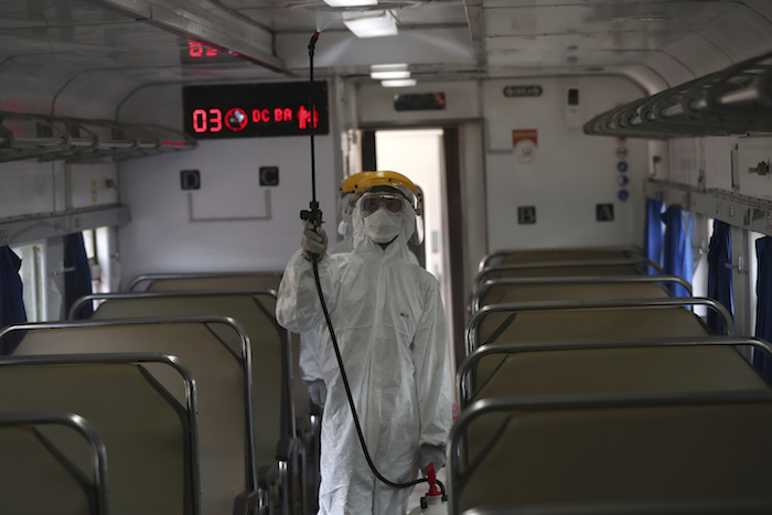 Un empleado con equipo de protección rocía desinfectante en un tren para combatir un brote de coronavirus en la estación de tren de Senen, en Yakarta, Indonesia, el domingo 15 de marzo de 2020. Foto: Tatan Syuflana, AP