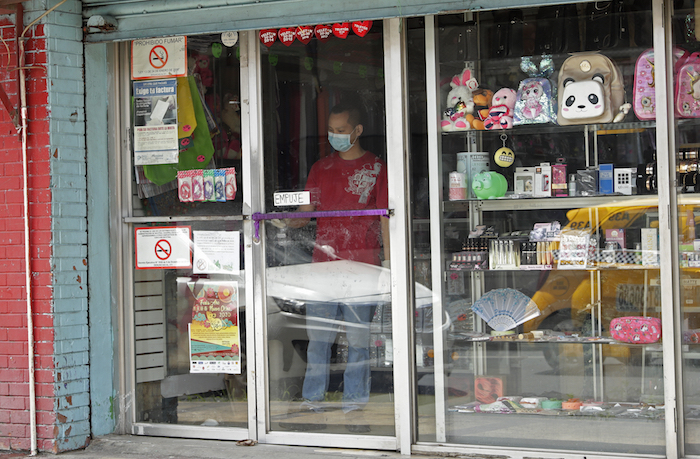 Un hombre con una mascarilla para protegerse de un posible contagio por coronavirus limpia la ventana de una tienda en el barrio "China Town" en la Ciudad de Panamá, el jueves 12 de marzo de 2020. Foto: Arnulfo Franco, AP