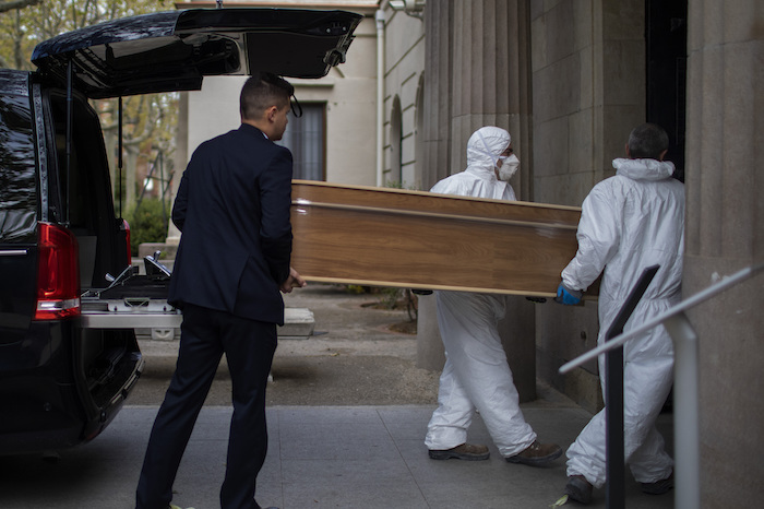 Empleados de una funeraria trasladan un ataúd para un entierro en un cementerio en Barcelona durante el brote del coronavirus en España, el viernes 27 de marzo de 2020. Foto: Emilio Morenatti, AP